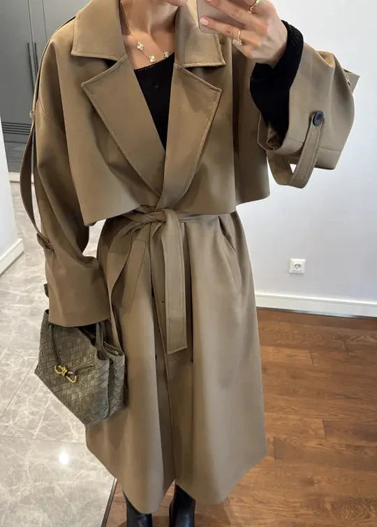 manteau long beige, trench femme, manteau ceinturé, mode féminine, vêtement femme, élégant, tendance, Stockholm, stockholm.ma, veste longue, automne, printemps, chic, prêt-à-porter, tenue femme, luxe abordable, outerwear femme, style moderne, beige classique, manteau mi-saison.